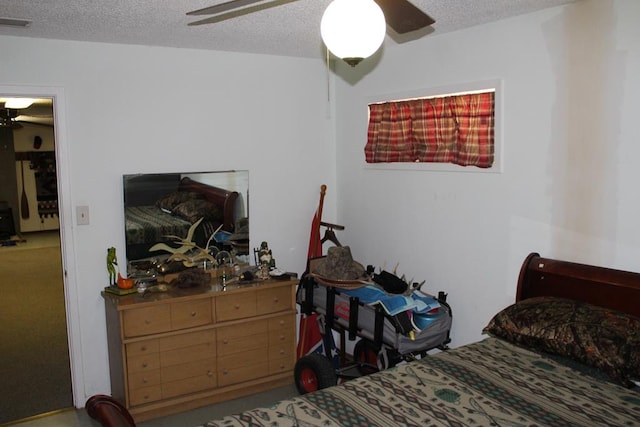 bedroom with ceiling fan and a textured ceiling