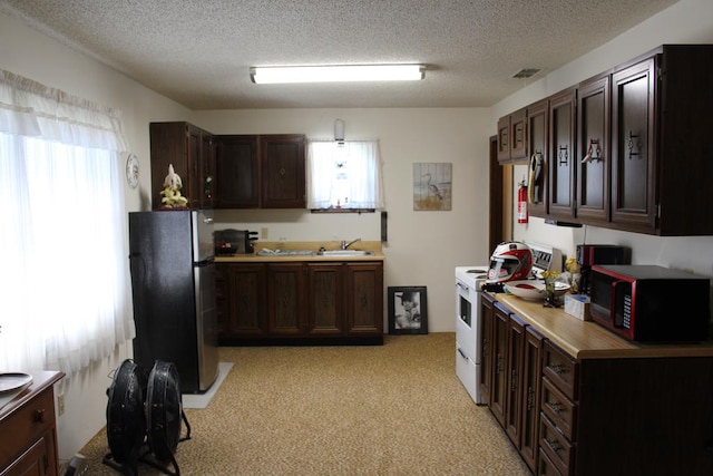 kitchen with stainless steel fridge, a textured ceiling, dark brown cabinetry, white range with electric stovetop, and sink