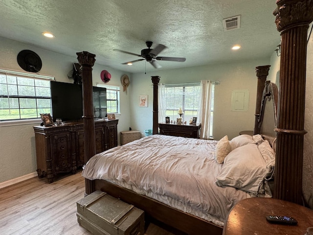 bedroom featuring decorative columns, recessed lighting, visible vents, light wood-style flooring, and a textured ceiling