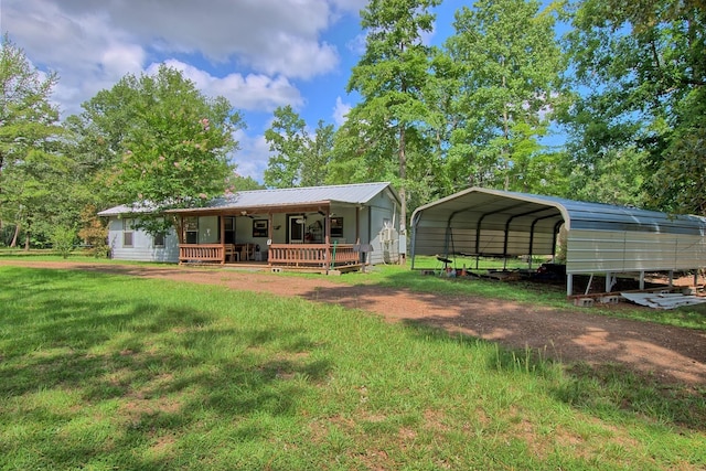 exterior space with a carport, covered porch, and a front yard