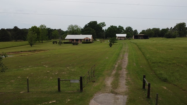 view of yard featuring fence, a rural view, and driveway