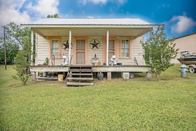 view of front facade featuring a porch, a front yard, and metal roof