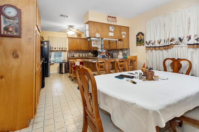 dining space featuring ceiling fan, visible vents, and light tile patterned floors