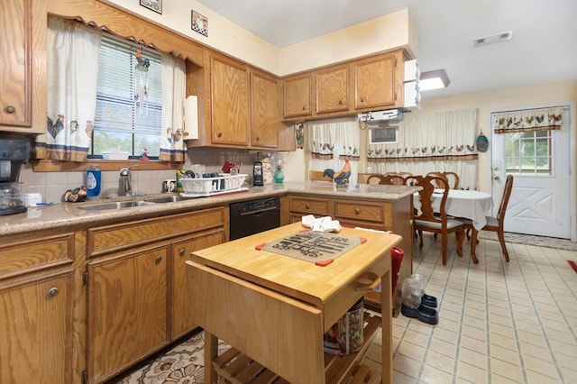 kitchen with brown cabinets, a sink, black dishwasher, tasteful backsplash, and visible vents
