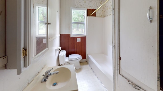 bathroom featuring vanity, a shower, toilet, and wood walls