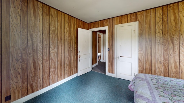 unfurnished bedroom featuring wood walls and dark colored carpet