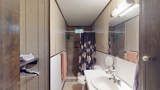 bathroom featuring toilet, sink, a textured ceiling, wooden walls, and curtained shower