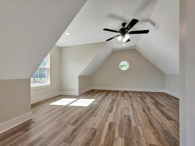 additional living space featuring vaulted ceiling, wood finished floors, baseboards, and ceiling fan