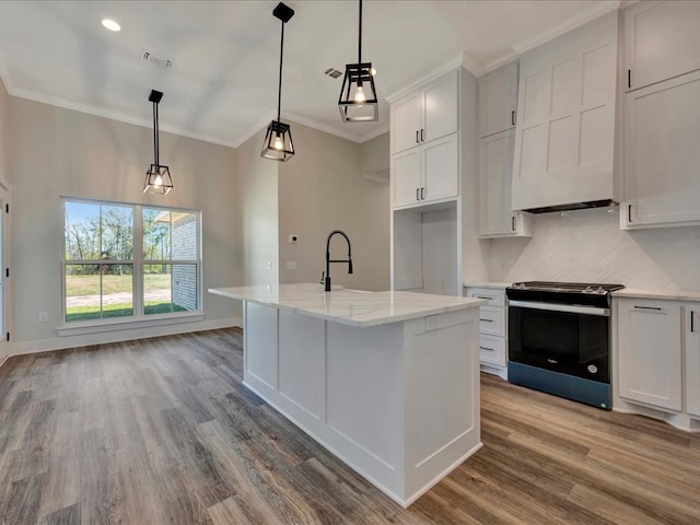 kitchen featuring hanging light fixtures, black / electric stove, a kitchen island with sink, white cabinets, and hardwood / wood-style flooring