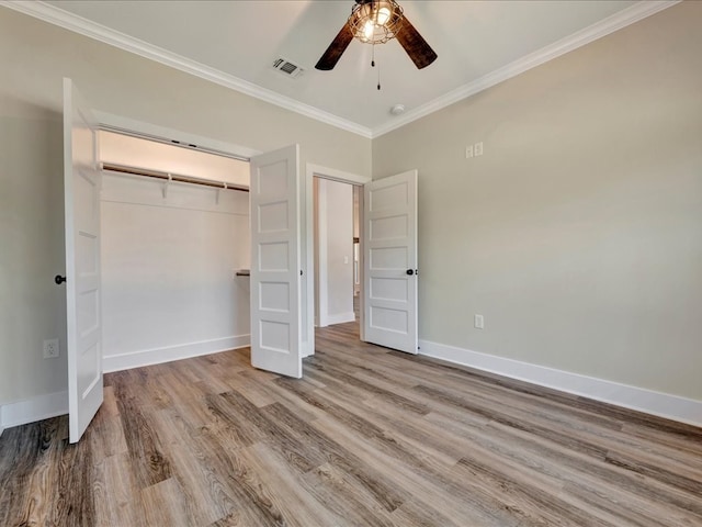 unfurnished bedroom with ceiling fan, light wood-type flooring, ornamental molding, and a closet