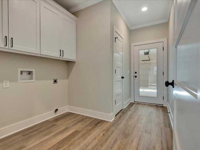 clothes washing area featuring electric dryer hookup, cabinets, light hardwood / wood-style flooring, washer hookup, and ornamental molding