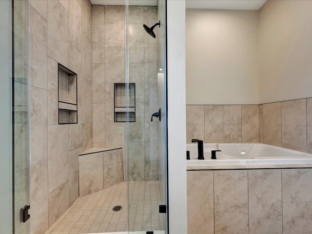 bathroom with a shower stall and a bath