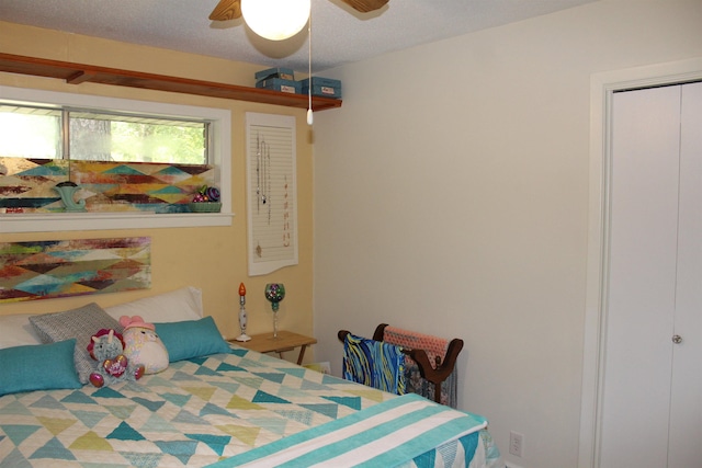 bedroom with ceiling fan, a closet, and a textured ceiling