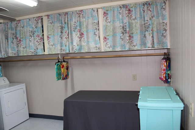 laundry room with wood walls and washing machine and dryer