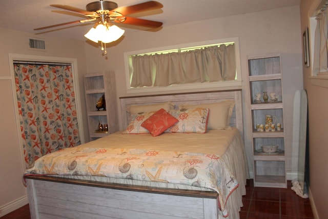 bedroom with dark tile patterned floors and ceiling fan