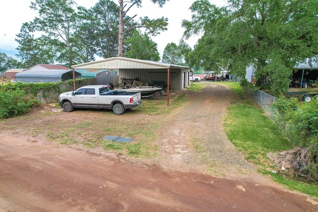view of front of house with fence, driveway, and a carport