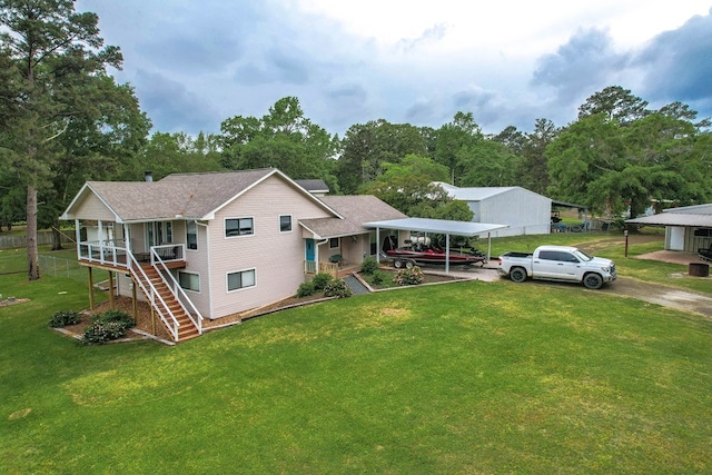 view of front of property with dirt driveway, stairs, a front lawn, a carport, and a porch