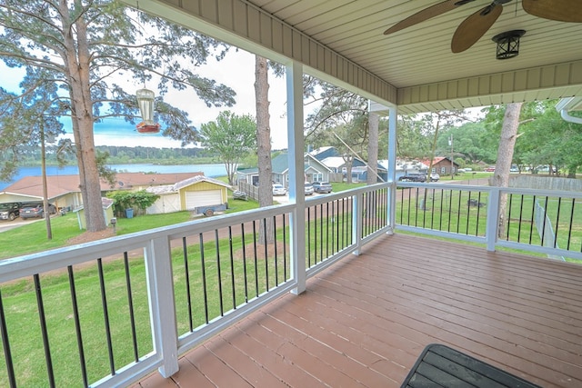 deck featuring a residential view, a water view, covered porch, a ceiling fan, and a yard