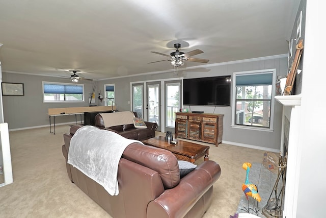 living area with ceiling fan, light carpet, and crown molding