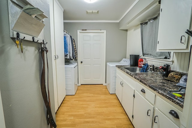 laundry area featuring visible vents, a sink, independent washer and dryer, light wood-type flooring, and crown molding