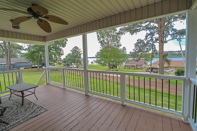 wooden deck featuring a residential view, a water view, a yard, and ceiling fan