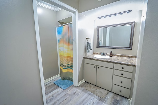bathroom with baseboards, wood finished floors, curtained shower, and vanity