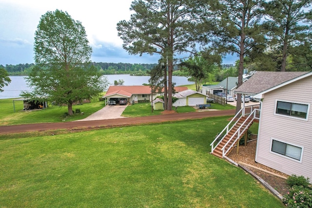 view of yard with driveway, a water view, and stairs