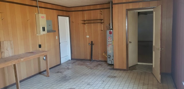 interior space featuring electric panel, wooden walls, and gas water heater