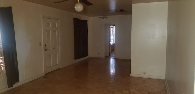 spare room featuring ceiling fan and parquet floors