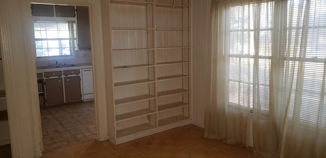 interior space with sink, parquet floors, and white dishwasher