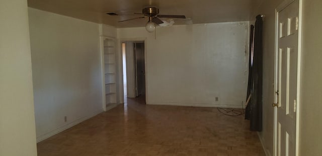 unfurnished room with ceiling fan and light parquet flooring