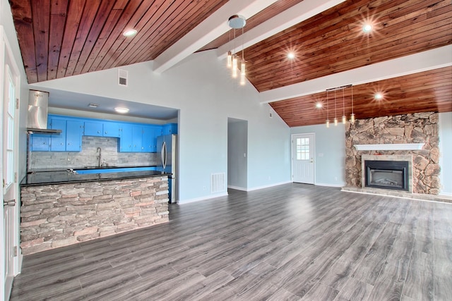 unfurnished living room featuring high vaulted ceiling, dark hardwood / wood-style floors, a stone fireplace, and wood ceiling