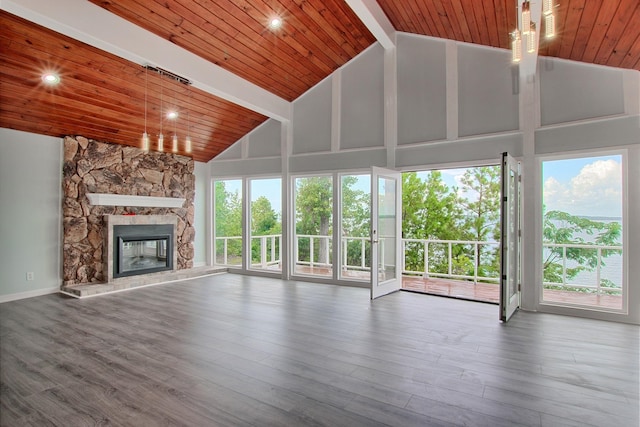 unfurnished living room featuring a stone fireplace, hardwood / wood-style floors, high vaulted ceiling, and a healthy amount of sunlight