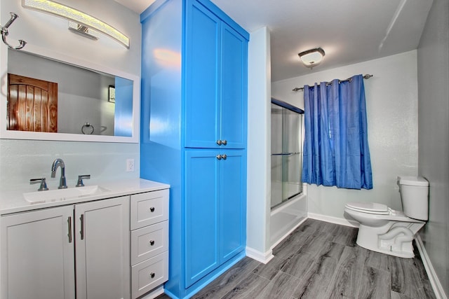 full bathroom featuring toilet, vanity, enclosed tub / shower combo, and wood-type flooring