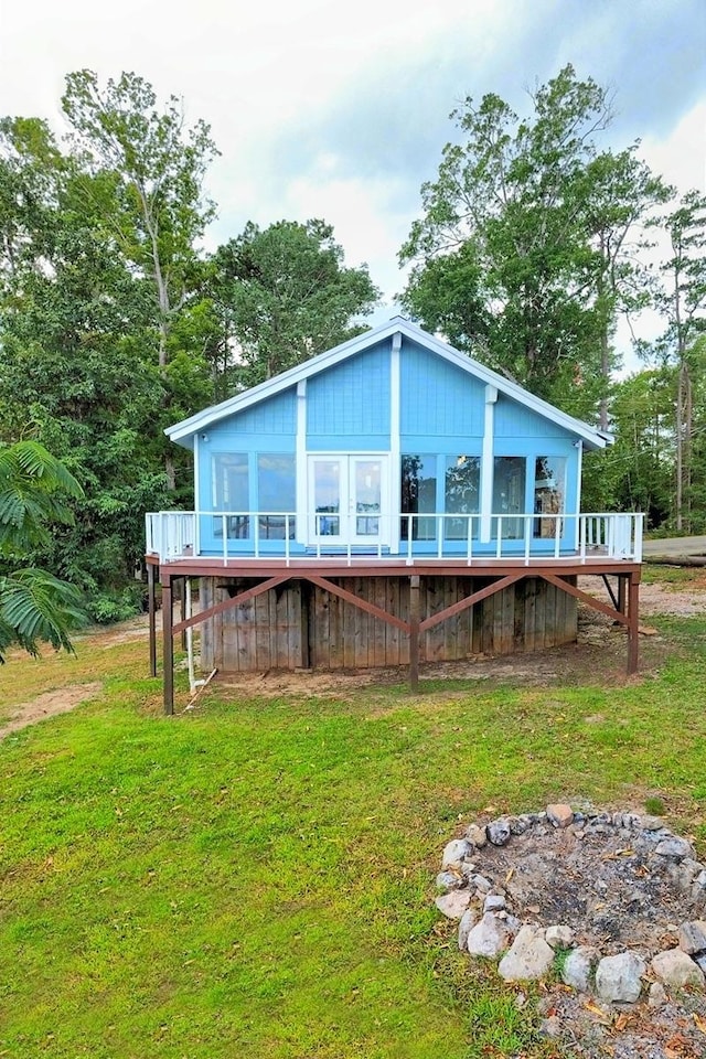 rear view of house with a deck and a yard