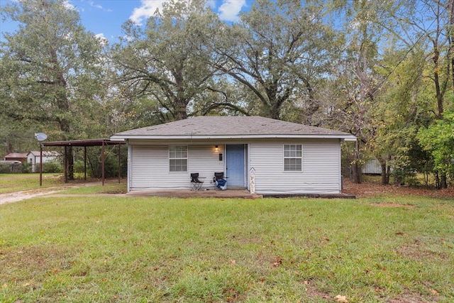 back of house with a carport and a yard