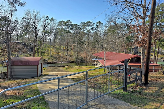 exterior space featuring an outbuilding, a shed, a detached garage, and fence