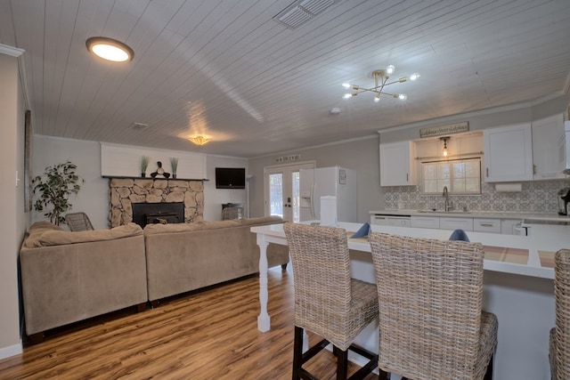 dining room with light wood-style flooring, wood ceiling, visible vents, and ornamental molding