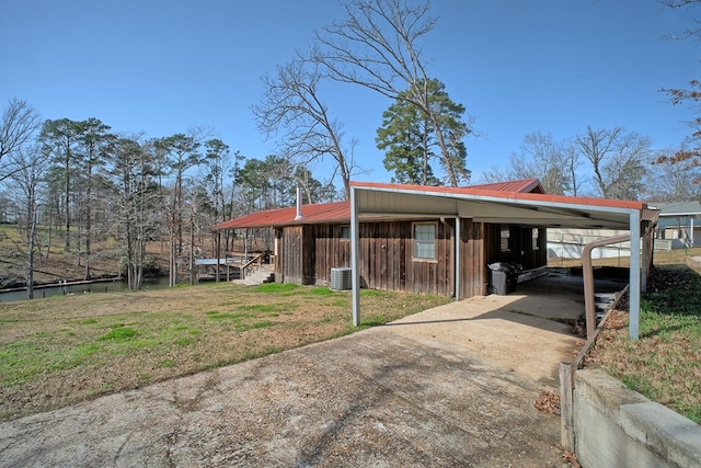 exterior space featuring central air condition unit, a carport, and driveway