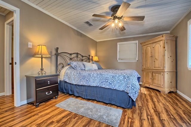 bedroom with wood finished floors, visible vents, baseboards, ceiling fan, and crown molding