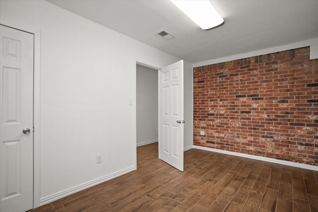 413 Linn St, Huntington, TX 75949 - empty room featuring dark wood-style floors, baseboards, and brick wall