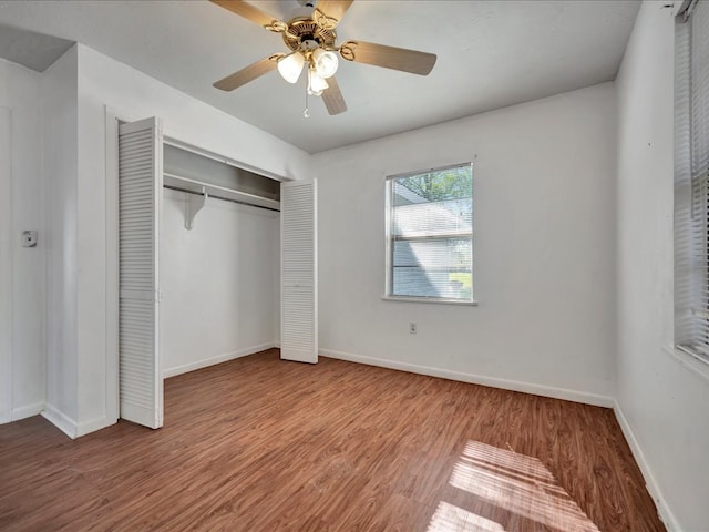 unfurnished bedroom with wood-type flooring, a closet, and ceiling fan