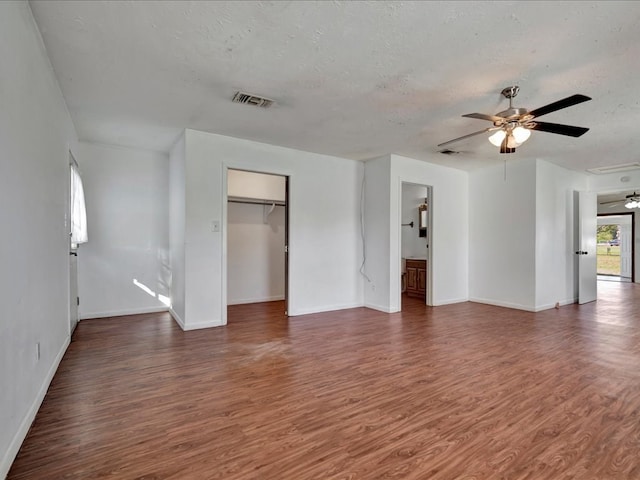 interior space with a textured ceiling, ceiling fan, and dark hardwood / wood-style floors