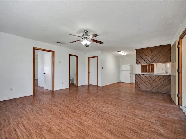 unfurnished living room with hardwood / wood-style flooring and a textured ceiling