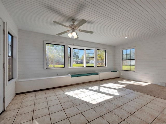 tiled empty room featuring plenty of natural light, ceiling fan, and wood ceiling