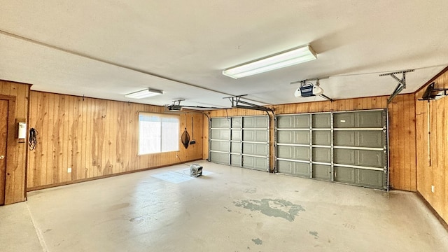 garage featuring a garage door opener and wooden walls