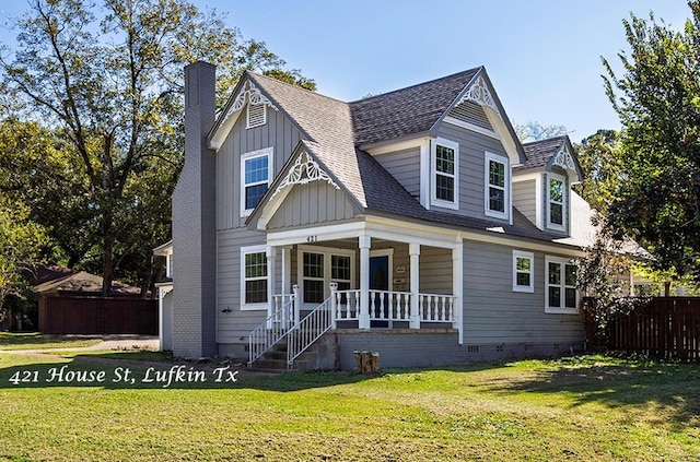 view of front of property featuring crawl space, board and batten siding, a front yard, fence, and covered porch