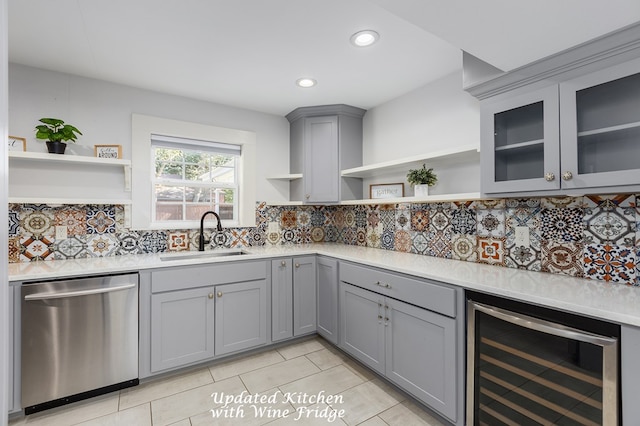 kitchen with a sink, stainless steel dishwasher, gray cabinetry, and open shelves