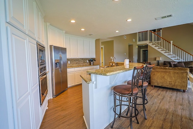 232 Cove Ln, Brookeland, TX 75931 - kitchen with stainless steel appliances, light wood-type flooring, open floor plan, decorative backsplash, and recessed lighting