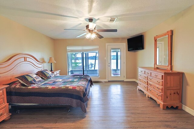 232 Cove Ln, Brookeland, TX 75931 - bedroom with access to outside, wood finished floors, baseboards, ceiling fan, and a textured ceiling